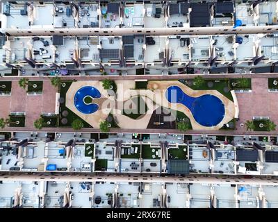 Spanien, Valencianische Gemeinschaft, MIL Palmeras, Luftansicht von Apartmentdächern mit Swimmingpool in der Mitte Stockfoto