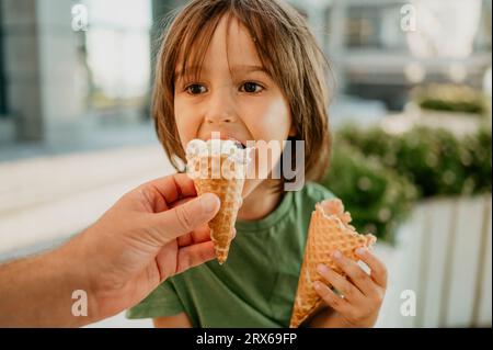 Vaters Hand fütterte dem Sohn Eis Stockfoto