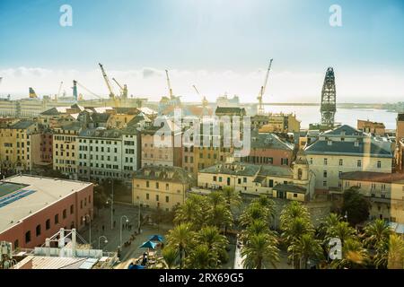 Italien, Ligurien, Genua, Wohnhäuser mit Hafenkranen im Hintergrund Stockfoto