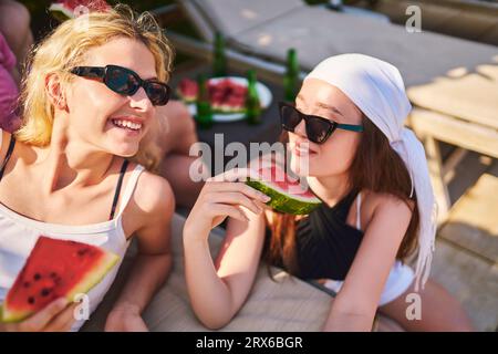 Glückliche Freunde halten Wassermelone und entspannen zusammen an einem sonnigen Tag Stockfoto