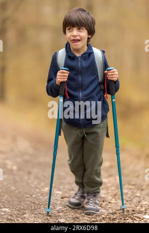 Niedlicher zahnloser Junge, der gerne in Wäldern wandert Stockfoto