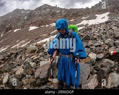 Müde Frau, die bei regnerischem Wetter den Berg absteigt, Falbesoner Valley, Stubaier Alpen, Österreich Stockfoto