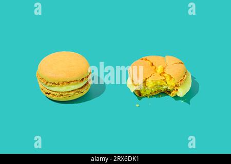 Zerstoßenes und vollständiges Macaroon auf türkisfarbenem Hintergrund Stockfoto