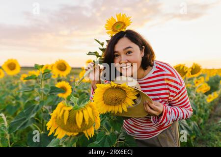 Glückliche Frau mit Hut im Sonnenblumenfeld Stockfoto