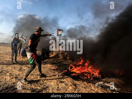 Gaza, Palästina. September 2023. Ein palästinensischer Demonstrant schießt eine Schleuder unter brennenden Reifen, während der Konfrontationen mit israelischen Sicherheitskräften entlang der Grenze zu Israel, östlich von Khan Yunis, südlich des Gazastreifens. Quelle: SOPA Images Limited/Alamy Live News Stockfoto