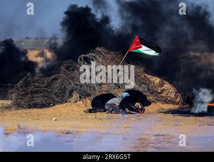 Gaza, Palästina. September 2023. Palästinensische Demonstranten verstecken sich unter brennenden Reifen, während Konfrontationen mit israelischen Sicherheitskräften entlang der Grenze zu Israel, östlich von Khan Yunis, südlich des Gazastreifens. Quelle: SOPA Images Limited/Alamy Live News Stockfoto