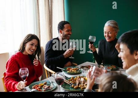 Glückliche Familie mit Rotwein und Abendessen an Weihnachten Stockfoto