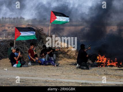 Gaza, Palästina. September 2023. Palästinensische Demonstranten erschießen Schleuderschüsse unter brennenden Reifen während der Konfrontationen mit israelischen Sicherheitskräften entlang der Grenze zu Israel, östlich von Khan Yunis, südlich des Gazastreifens. Quelle: SOPA Images Limited/Alamy Live News Stockfoto