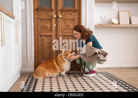 Frau streichelt Hund sitzt auf Teppich zu Hause Stockfoto