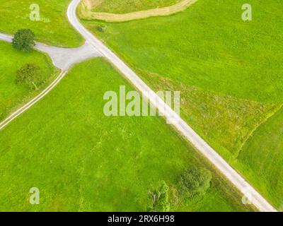 Spanien, Kantabrien, San Vicente de la Barquera, Luftaufnahme der Landstraße, die sich im Sommer zwischen grünen Feldern erstreckt Stockfoto