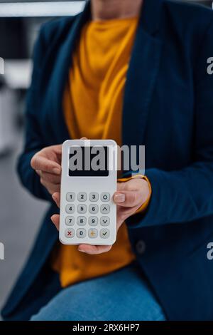 Hände einer Geschäftsfrau mit modernem Kreditkartenleser Stockfoto