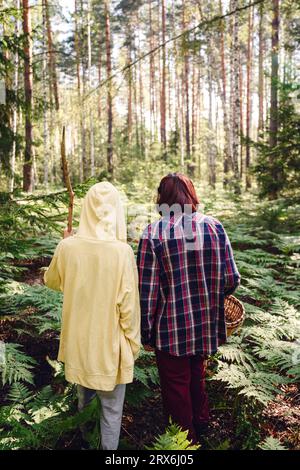 Junge mit Großmutter, der im Wald spaziert Stockfoto