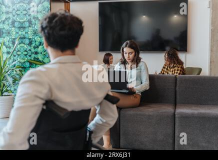 Zwei freiberufliche Mitarbeiter können ihre Projekte diskutieren, während sie an einem Tisch im modernen Café sitzen Stockfoto