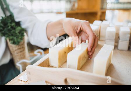 Hand einer Frau, die im Geschäft duftende Seife pflückt Stockfoto