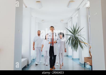 Eine zufriedene Gruppe von selbstbewussten Krankenpflegern in einem Krankenhaus. Ärzte, Spezialisten und Arbeiter posieren in ihren medizinischen Uniformen, lächeln und versorgen Stockfoto