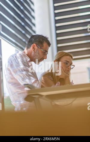 Fokussierte Geschäftsleute, die den Erfolg in modernen Büroumgebungen planen. Stockfoto