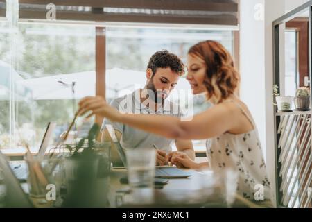 Markenmanager, die in modernen Büros zusammenarbeiten. Sie tauschen Ideen aus, optimieren Marketingstrategien und binden Kunden über Daten Stockfoto