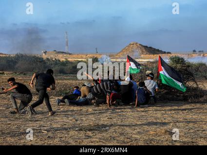 Die Demonstranten verstecken sich, während sie palästinensische Flaggen während der Konfrontationen mit israelischen Sicherheitskräften entlang der Grenze zu Israel, östlich von Khan Yunis, südlich des Gazastreifens, halten. (Foto von Yousef Masoud/SOPA Images/SIPA USA) Stockfoto