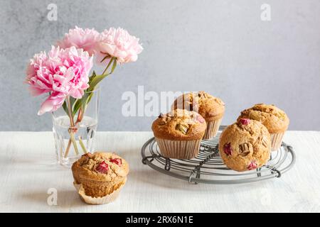 Studioaufnahme von rosa Pfingstrosen und Rhabarber-Muffins auf Kühlregal Stockfoto