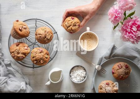Hand einer Frau, die Rhabarber-Muffin aufnimmt Stockfoto