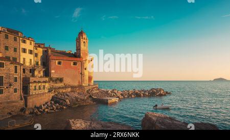 Tellaro Dorf bei Sonnenuntergang. Die Kirche und ein kleines Boot im Meer. Golfo dei Poeti oder Golf der Dichter. Ligurien Region, Italien, Europa. Stockfoto