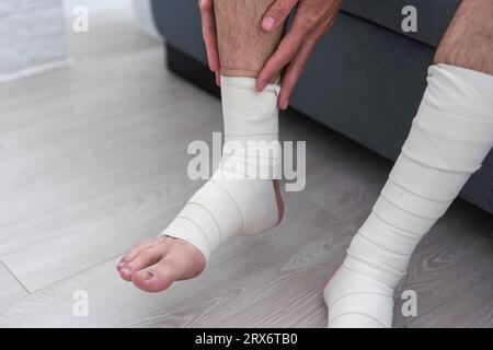 Das Bein des Mannes ist in einen elastischen Verband gewickelt Stockfoto