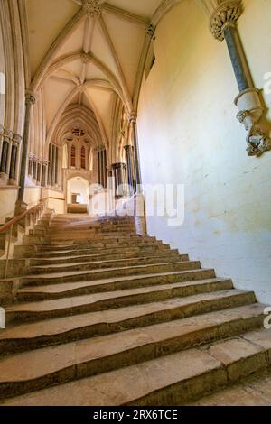 Die gut abgenutzte und historische Steintreppe führt zum Chapter House in Wells Cathedral, Somerset, England, Großbritannien Stockfoto