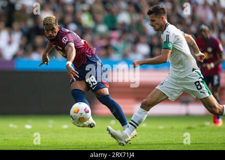 23. September 2023, Nordrhein-Westfalen, Mönchengladbach: Fußball: Bundesliga, Borussia Mönchengladbach - RB Leipzig, Spieltag 5, Stadion im Borussia-Park. Der Leipziger Benjamin Henrichs (l) spielt den Ball. Gladbachs Julian Weigl läuft rechts. Foto: Marius Becker/dpa - WICHTIGER HINWEIS: Gemäß den Anforderungen der DFL Deutsche Fußball Liga und des DFB Deutscher Fußball-Bund ist es verboten, im Stadion und/oder im Spiel aufgenommene Fotos in Form von Sequenzbildern und/oder videoähnlichen Fotoserien zu verwenden oder zu verwenden. Stockfoto