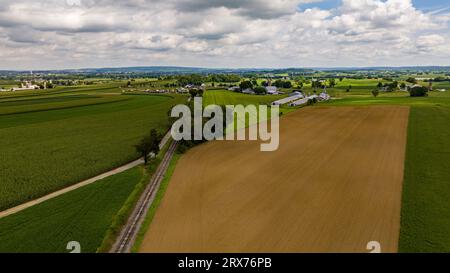 Aerial View of Rural America, mit Farmland und einer Single Rail Road Track, die durch das Land führt. Stockfoto