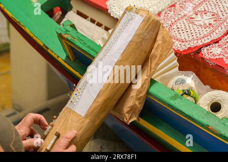 Gozo, Malta - 5. August 2023: Person, die Souvenirgeschenke in Spitze mit traditionellen Methoden und Ausrüstung macht. Stockfoto