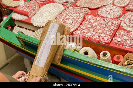 Gozo, Malta - 5. August 2023: Person, die Souvenirgeschenke in Spitze mit traditionellen Methoden und Ausrüstung macht. Stockfoto