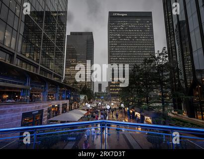 Canary Wharf, London, UK: Reuters Plaza in Canary Wharf mit Blick auf das JP Morgan Gebäude. Von der Südkolonnade aus gesehen, mit Menschen, die im Regen spazieren Stockfoto