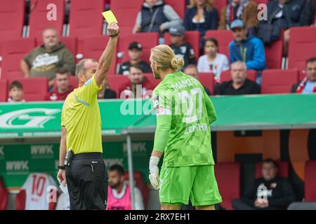 Augsburg, Deutschland. September 2023. Fußball: Bundesliga, FC Augsburg - FSV Mainz 05, Spieltag 5, WWK Arena. Der Schiedsrichter Marco Fritz (l) zeigt dem Mainzer Torhüter Robin Zentner die gelbe Karte. Kredit: Peter Fastl/Kolbert-Press/dpa - WICHTIGER HINWEIS: gemäß den Anforderungen der DFL Deutsche Fußball Liga und des DFB Deutscher Fußball-Bund ist es untersagt, im Stadion und/oder im Spiel aufgenommene Fotografien in Form von Sequenzbildern und/oder videoähnlichen Fotoserien zu nutzen oder nutzen zu lassen./dpa/Alamy Live News Stockfoto