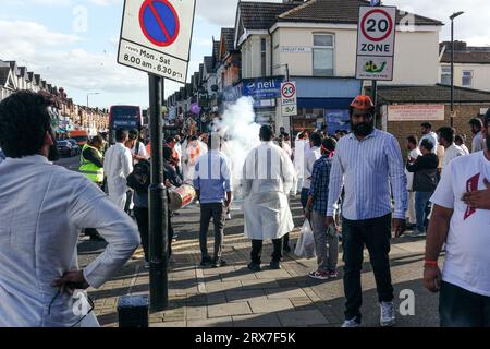 London, Großbritannien. September 2023. Eine Prozession von hinduistischen Gläubigen in East Ham feiert das jährliche Festival Ganesh UTNG, während sie vor einer Statue von Ganesha spazieren, die von einigen der Gläubigen gehalten wird. Singen und tanzen im Rhythmus der Trommeln, während ein Feuerwerk in den Straßen von einigen der feiernden Gemeinde ausgelöst wird. © Simon King/Alamy Live News Stockfoto