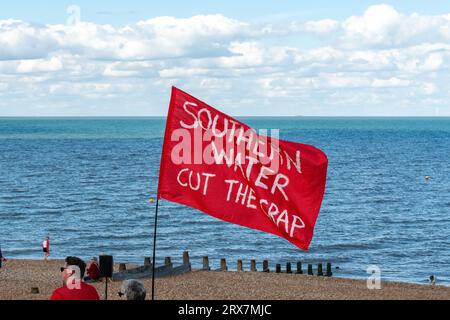 Eine rote Flagge mit der Aufschrift „SOUTHERN WATER CUT THE MIST“, die von einem Demonstranten beim SOS Whitstable-Protest über die Freisetzung von Abwasser aus dem südlichen Wasser in das Meer gehalten wurde. Stockfoto