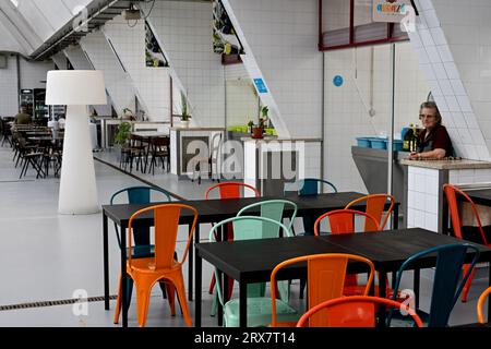 Restaurant mit fast leeren Tischen und Stühlen auf dem städtischen Markt in Porto, Portugal Stockfoto