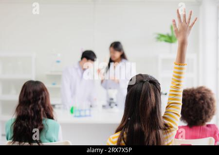 Kluge Schüler, die Hand in die Hand nehmen, haben eine Frage an Wissenschaftler, die im modernen Klassenzimmer der Wissenschaft eine Rolle spielen Stockfoto