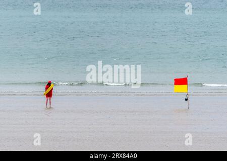 Weibliche RNLI-Rettungsschwimmerin im Dienst in Inchydoney Beach, West Cork, Irland. Stockfoto