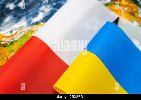 Flaggen Polens und der Ukraine vor dem Hintergrund der Welt, wirtschaftliches und politisches Konzept, Zusammenarbeit und gegenseitige Beziehungen beider Länder Stockfoto