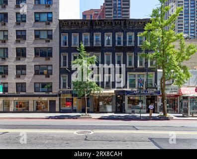 Die schwarze Beschichtung blättert von der grauen Ziegelfassade der 245-249 East 57th Street ab, drei vierstöckigen Reihenhäusern in Midtown Manhattan. Stockfoto