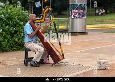 Alter Mann sitzend und spielend Harfe Musikinstrument, Hito Tres Fronteras oder Triple Frontier, Dreiländereck zwischen Brasilien, Argentinien, Paraguay Stockfoto