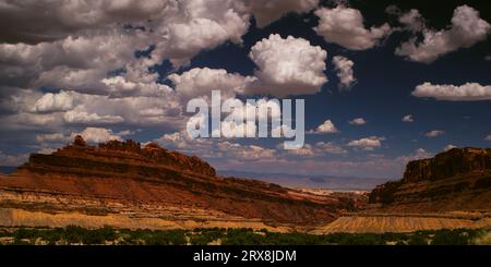 Traumhafte Cumuluswolken schweben an einem idyllischen Sommertag über dem Black Dragon Canyon in San Rafael Swell, Utah. Stockfoto