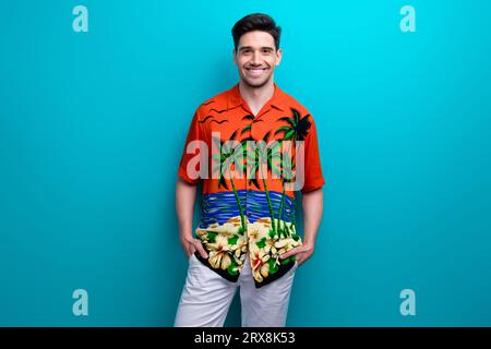 Foto von jungen lustigen Mann Hände Taschen Shopping Modell Marke Store Macho Kauf Dschungel Print Shirt isoliert auf blauem Hintergrund Stockfoto