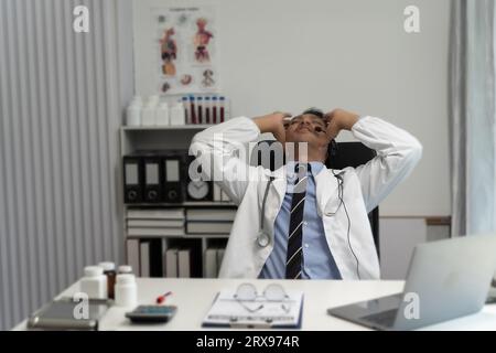 Gestresster Arzt sitzend Stress Kopfschmerzen über die Arbeit im Krankenhaus medizinische Problem Praktiker unglücklich, verzweifelt, erschöpft, frustriert, Kopfschmerzen Gesundheit Stockfoto