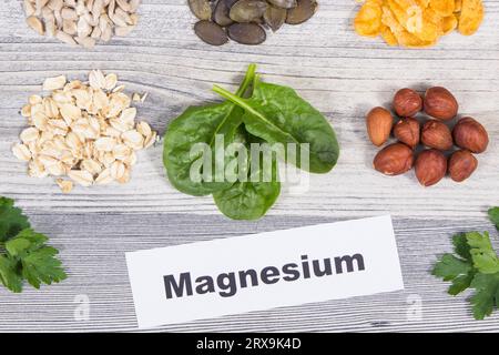 Inschrift Magnesium, gesunde nahrhafte Lebensmittel und verschiedene Zutaten, die natürliches Magnesium und andere Vitamine und Mineralien enthalten Stockfoto