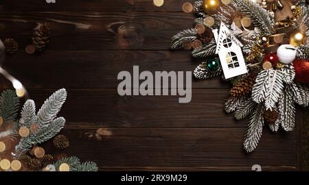 Weihnachtskranz auf dunklem hölzernem Hintergrund mit Kopierraum und Bokeh. Rustikale, festliche Vintage-Dekoration. Banner. Weihnachtsabendkarte. Draufsicht Stockfoto