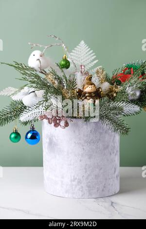 Weihnachtskomposition in samtgrauer Box mit Fichte, Farn zur Tischdekoration. Verschneite Strähnen mit Wackeln, Vogel in wunderschöner Verpackung, zusammengebaut von Stockfoto