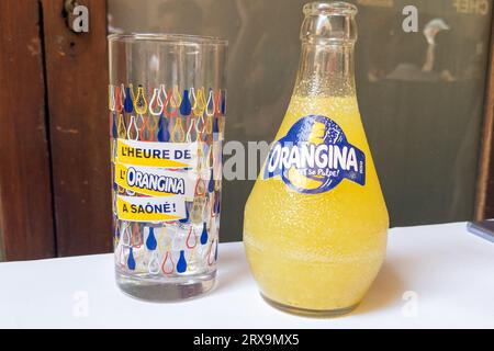 Bordeaux, Frankreich - 09 22 2023 : Orangina Orange Limonade karbonisiertes Logo-Zeichen und Markentext auf der Manschette mit leerem Soda-Branding-Glas Stockfoto