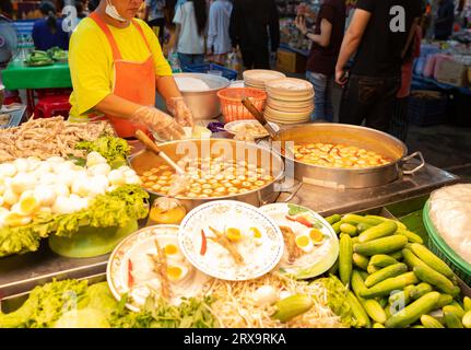 Fleischbällchen in Fischsuppe ein Topf, der mit Reisnudeln in Fischcurry-Sauce mit Gemüse auf dem Straßenmarkt gegessen wird. Stockfoto