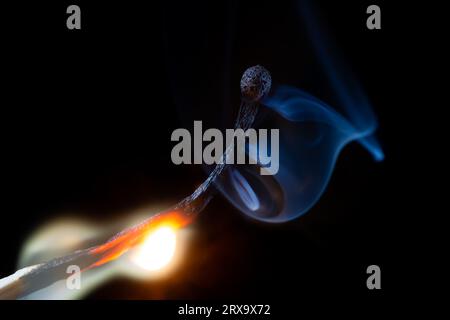 Brennendes Holzspiel auf schwarzem Hintergrund. Makrofotografie. Stockfoto